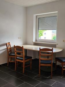 Töging am Inn的住宿－Stadthostel，客房设有桌子、两把椅子和窗户。