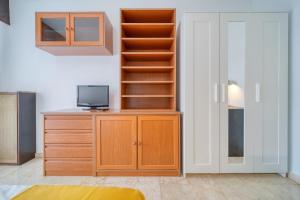 Habitación con estantería de libros y escritorio con TV. en CasaCafé Madrid Pozuelo 2 Baño Fuera de la habitacion o COMPARTIDO en Pozuelo de Alarcón