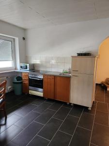 a kitchen with a refrigerator and a sink in it at Stadthostel in Töging am Inn