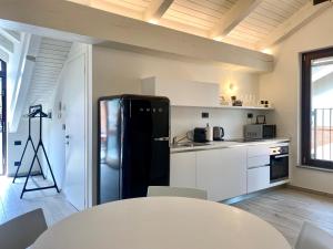 a kitchen with a black refrigerator and a table at Casa di Nuvola -Residenza Lavinia - in Monforte dʼAlba