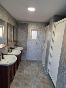 a bathroom with four sinks and a row of mirrors at Glamping Livada cu lavanda 