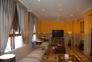 salon z kanapą i telewizorem w obiekcie Hotel Casa José Díaz w mieście San Agustín de Guadalix