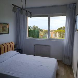 1 dormitorio con cama y ventana grande en Apartamento con jardin privado junto playa Usil - Mogro en Miengo