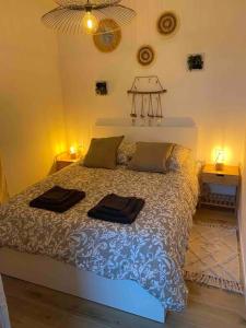 1 dormitorio con 1 cama con 2 toallas en Escapade Normande avec son sauna privé, en Le Tourneur