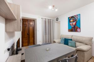 ein Wohnzimmer mit Tisch und Couch in der Unterkunft Designer HOME with COMFY SOFA in central Valletta by 360 Estates in Valletta