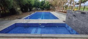 a swimming pool with blue tiles on the ground at VIVIDEARTH Resorts Bandipur in Bandipūr