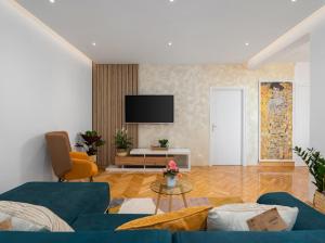 a living room with a blue couch and a tv at Luxury Apartment Beyond in Stobreč