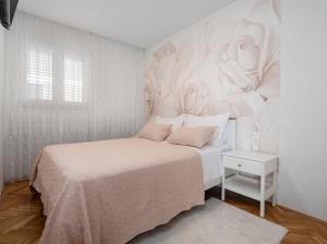 a bedroom with a bed with a white wall at Luxury Apartment Beyond in Stobreč