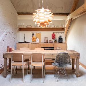 a dining room with a wooden table and chairs at GRAACE Suite in Luxembourg