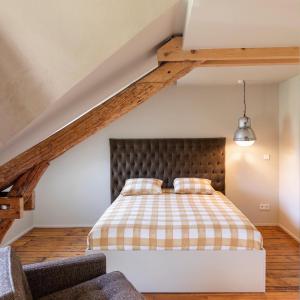 a bedroom with a bed with a checkered blanket at GRAACE Suite in Luxembourg