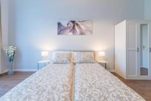 a large bed in a room with two lamps at Downtown Heart 3bdr Jokai square AC in Budapest