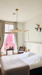 1 dormitorio con cama blanca y ventana en Hotel Greate Pier, en Kimswerd