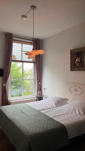 a bedroom with a bed and a large window at Hotel Greate Pier in Kimswerd