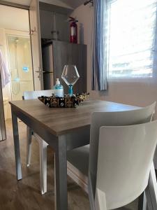 a dining room table with two white chairs and a table at Mobilhome 516 in La Teste-de-Buch