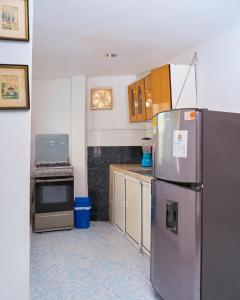 a kitchen with a refrigerator and a stove at Hostel ISABELLA in Santa Marta