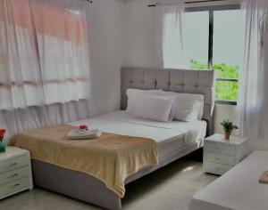 a bedroom with a large bed with a large window at Hotel Campestre Atardecer Cafetero in Quimbaya