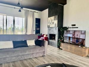 a living room with a couch and a fireplace at Villa de Ferme Wafaa - Location de Rêve avec Piscine près de Mazagan in El Jadida