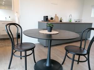 einen Tisch und zwei Stühle in einer Küche in der Unterkunft Blackwood cottage near Geysir in Reykholt