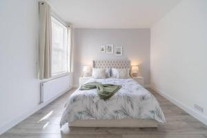 una camera bianca con un letto e una finestra di Stunning 3 bedroom flat in Southend-on-sea a Southend-on-Sea