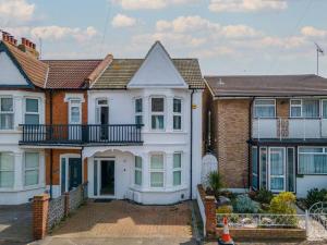 a white house with a balcony on a street at Stunning 3 bedroom flat in Southend-on-sea in Southend-on-Sea
