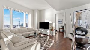 a living room with a white couch and a tv at Luxurious 4 BR Penthouse in NYC in New York