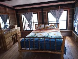 um quarto com uma cama num chalé de madeira em Aqeel cabin in the nature em Penonomé