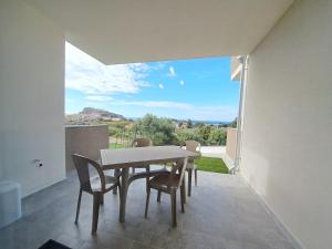 Un comedor con mesa y sillas en un balcón. en Appartamento Armony, en Castelsardo