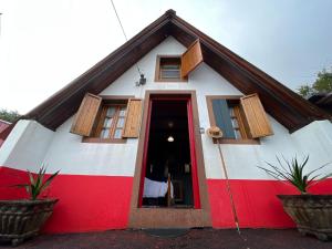 una casa roja y blanca con una puerta roja en Abrigo da Serra- Nature Trails, en Santana