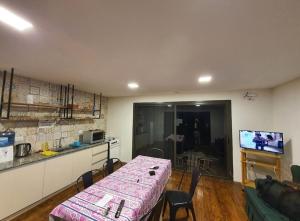 sala de estar con mesa y cocina en Mendoza San Isidro Cabaña en Mendoza