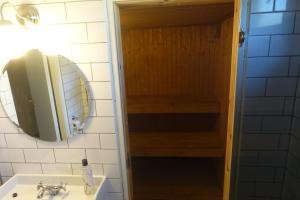 een badkamer met een wastafel en een spiegel bij Spacious house with sauna 2 bathrooms and indoor pingis table! in Hestra