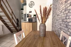 a vase sitting on a wooden table in a kitchen at Kedge 5 - proche centre, tram & universités in Talence