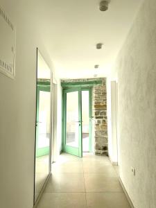 einen leeren Flur mit Tür und Spiegel in der Unterkunft Damir Skomina Apartments in Koper