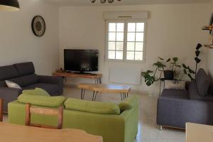 a living room with two couches and a tv at Le Bellevue à 1 h 30 de Paris et 20 km de Troyes in Estissac
