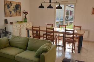 a living room with a couch and a table with chairs at Le Bellevue à 1 h 30 de Paris et 20 km de Troyes in Estissac