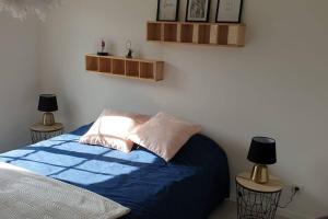 a bedroom with a bed with blue sheets and two lamps at Le Bellevue à 1 h 30 de Paris et 20 km de Troyes in Estissac