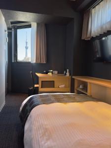 東京的住宿－FL飯店 浅草東上野，一间卧室配有一张床,窗户带有塔楼