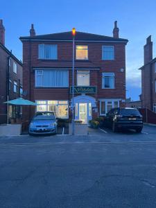 two cars parked in front of a brick building at The Northdale Hotel Ltd in Skegness