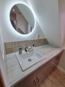 een badkamer met een wastafel en een spiegel bij The Swish - New Forest Get Away in Redlynch