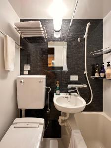 a bathroom with a white toilet and a sink at FL Hotel Asakusa in Tokyo