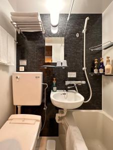 a bathroom with a white toilet and a sink at FL Hotel Asakusa in Tokyo