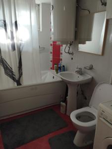 a bathroom with a toilet and a sink and a tub at Apartman Aleksandra in Smederevo +17 photos