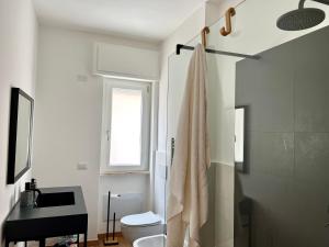 Baño blanco con lavabo y aseo en Cityside apartment, en Selargius