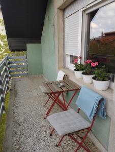 a table and chairs on a balcony with a window at Apartman Aleksandra in Smederevo