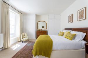 a bedroom with a bed with a yellow blanket on it at Bowden Retreats in Dartmouth