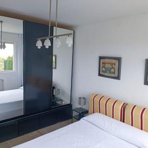 a bedroom with a mirror and a bed at Apartamento con jardin privado junto playa Usil - Mogro in Miengo