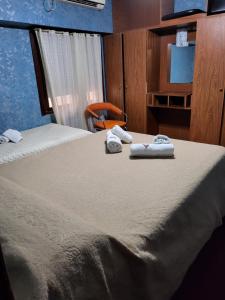 a bedroom with a bed with towels on it at Hotel Acuarius in La Plata