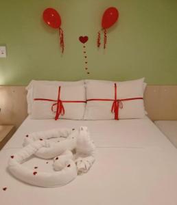 a bed with red hearts and balloons on the wall at Gran Lençóis Flat Residence in Barreirinhas
