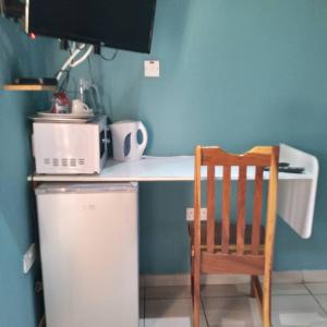 a kitchen with a table and a chair next to a counter at Kadavu Accommodations in Maun