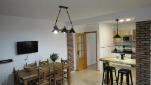 una cucina e una sala da pranzo con tavolo e sedie di El Rincón de Alejandro ad Arroyo Frio