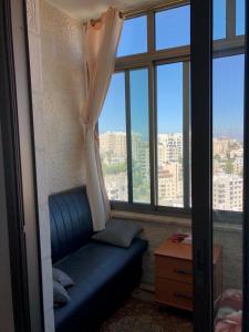 a room with a blue couch in front of a window at King castle in Ramallah